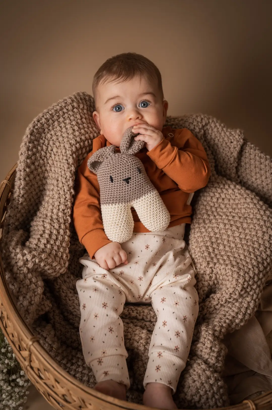 Baby met gehaakte konijn knuffel in stoel, handgemaakt baby speelgoed in neutrale kleuren